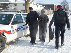 Police officers stage themselves outside of B. Davison Secondary School on Trafalgar Street after the school received a call shortly after 9 a.m. that a student would be bringing a weapon to class at the high school in London, Ontario on Friday January 9, 2015.  London Police locked down the school and surrounding neighbourhood, asking neighbours to stay indoors while they located the weapon, which turned out to be a cap gun, and took a student into custody, leading him from the building in handcuffs.
CRAIG GLOVER/The London Free Press/QMI Agency