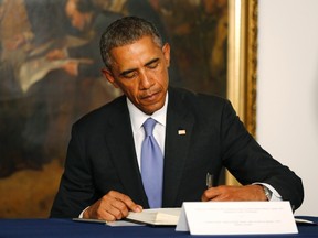 U.S. President Barack Obama signs a condolences book as he pays his respects for victims of the attack at the French newspaper Charlie Hebdo, during a visit to the French Embassy in Washington, January 8, 2015. REUTERS/Jim Bourg    (UNITED STATES - Tags: POLITICS CRIME LAW)