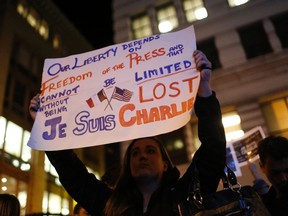 Tara Manning, an American who works for a French-American Company, holds a sign as people gather for a vigil outside the Consulate General of France to pay tribute to the victims of an attack on satirical magazine Charlie Hebdo in Paris, in San Francisco, California January 7, 2015. The youngest of three French nationals being sought by police for a suspected Islamist militant attack that killed 12 people at a satirical magazine on Wednesday turned himself in to the police, an official at the Paris prosecutor's office said. The hooded attackers stormed the Paris offices of Charlie Hebdo, a weekly known for lampooning Islam and other religions, in the most deadly militant attack on French soil in decades. REUTERS/Stephen Lam (UNITED STATES - Tags: CRIME LAW POLITICS CIVIL UNREST)