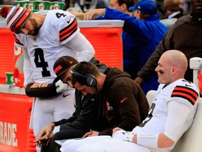Quarterback Connor Shaw #9 of the Cleveland Browns sits with Offensive Coordinator Kyle Shanahan and Quarterback Tyler Thigpen #4 during the first half of a game against the Baltimore Ravens at M&T Bank Stadium on December 28, 2014 in Baltimore, Maryland.  Rob Carr/Getty Images/AFP
