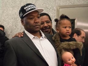 Derrick Hamilton, who served 21 years of a life sentence for murder, stands with his daughter Maia, 2, during a news conference after his conviction was vacated at Brooklyn Supreme Court in New York January 9, 2015. Hamilton, was formally cleared of murder on Friday after serving 21 years in prison, one of dozens of questionable murder convictions linked to a retired police homicide detective.
 REUTERS/Stephanie Keith