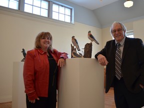 Cheryl and Brian Hepperle stand among their life-like carvings during a reception for their exhibit at the Multicultural Heritage Centre on Jan. 4. - Thomas Miller, Reporter/Examiner