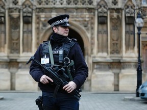 An armed police officer patrols outside the Houses of Parliament in London January 9, 2015.  The British government said on Thursday it had increased security at its borders, including at ports and at checkpoints it operates on French soil, in response to the deadly attack on the office of weekly newspaper Charlie Hebdo in Paris.  REUTERS/Luke MacGregor