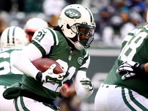 Running back Chris Johnson #21 of the New York Jets carries the ball in the first quarter against the New England Patriots during a game at MetLife Stadium on December 21, 2014 in East Rutherford, New Jersey.  Al Bello/Getty Images/AFP
