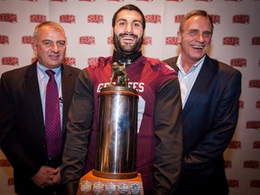 University of Ottawa athletic director Luc Gelineau (right) and football coach Jamie Barresi stand with Ettore Lattanzio, winner of university football's outstanding lineman award, Nov. 27 in Montreal. (QMI Agency)
