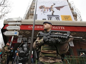 French soldiers patrol near a department store in Paris as part of the highest level of "Vigipirate" security plan in Paris January 10, 2015. French police searched for a female accomplice to militant Islamists behind deadly attacks on the satirical Charlie Hebdo weekly newspaper and a kosher supermarket and maintained a top-level anti-terrorist alert ahead of a Paris gathering with European leaders and demonstration set for Sunday. In the worst assault on France's homeland security for decades, 17 victims lost their lives in three days of violence that began with an attack on the Charlie Hebdo weekly on Wednesday and ended with Friday's dual hostage-taking at a print works outside Paris and kosher supermarket in the city.    REUTERS/Eric Gaillard