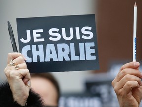 An employee of the Council of Europe holds a placard which read "I am Charlie" and a pen, during a minute of silence in front of the Council of Europe in Strasbourg January 9, 2015, two days after gunmen stormed weekly satirical newspaper Charlie Hebdo in Paris. The two main suspects in the weekly satirical newspaper Charlie Hebdo killings were sighted on Friday in the northern French town of Dammartin-en-Goele where at least one person had been taken hostage, a police source said.    REUTERS/Vincent Kessler