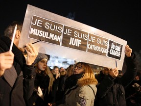 People hold a placard which reads "I am Muslim, I am Jewish, I am Catholic, I am Charlie" at a vigil, following the shooting of 12 people at the satirical newspaper Charlie Hebdo, at the Place de la Republic in Paris January 8, 2015. Picture taken January 8, 2015.  REUTERS/Jacky Naegelen