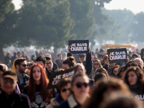 People march holding signs reading "je suis Charlie" ("I am Charlie'') in front of the White Tower, the symbol of the city, in Thessaloniki on January 11, 2015 in tribute to the 17 victims of a three-day killing spree by homegrown Islamists, in France. The killings began on January 7 with an assault on the Charlie Hebdo satirical magazine in Paris that saw two brothers massacre 12 people including some of the country's best-known cartoonists, the killing of a policewoman and the storming of a Jewish supermarket on the eastern fringes of the capital which killed 4 local residents. AFP PHOTO /SAKIS MITROLIDIS