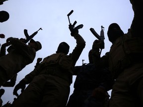 Iraqi policemen raise their weapons during a training session at a camp in the Bardarash district, 30 kilometres northeast of Mosul on January 10, 2015 as they prepare to recapture the northern Iraqi city of Mosul, currently under the control of Islamic State (IS) group fighters. IS spearheaded a sweeping militant offensive in June that overran large areas north and west of Baghdad, and also holds significant territory in Iraq and Syria. AFP PHOTO / SAFIN HAMED