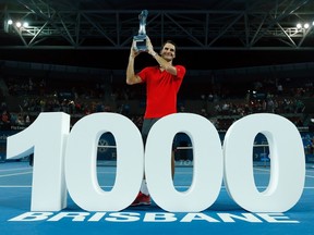 Roger Federer of Switzerland poses with a giant number 1,000 after winning his thousandth career title in the men's singles final at the Brisbane International tennis tournament in Brisbane, January 11, 2015. Federer defeated Milos Raonic of Canada in three sets to mark the milestone. REUTERS/Jason Reed