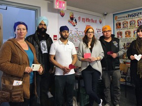 (Left to right) Tymmarah Zehr, Thelwinder Singh Sanhu, Iftikhar Sayed, Tatiana Wugalter and Chris Coutrie and Lelannie Lewis display messages from the community at Sri Guru Singh Sabha gurdwara in Edmonton, Alta. on Sunday, Jan. 11, 2015. The John Humphrey Centre for Peace and Human rights visited the gurdwara at 4504 Mill Woods Road South on Sunday following bigoted graffiti messages being scrawled on the building either Thursday night or Friday morning.​ Catherine Griwkowsky/Edmonton Sun/QMI Agency