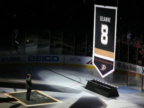 Teemu Selanne stands on the ice as his banner is raised during ceremonies retiring his number on Sunday. (STEPHEN DUNN/Getty)