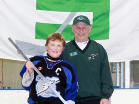 Forest tournament co-director Rick Allen presents a Silver Stick to Mariposa Lightning captain Logan Jenkins after his club won the peewee C final with a 3-0 victory over Belmont. Four champions were crowned as the first half of the annual tournament in Forest wrapped up on Sunday. (TERRY BRIDGE/THE OBSERVER)