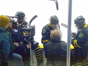 Production crew members film a sequence during the Sarnia Sting minor midget MD team's game at Sarnia Arena with head coach Ken Ayers, middle, talking to his team. From left are players Nathan Moro, Jordy Grondin and Nick Cooper. (SUBMITTED PHOTO)