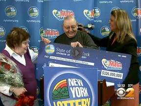 Harold Diamond, middle, is presented with an oversized cheque after winning the $326 million Mega Millions jackpot. (CBS NewYork screengrab)