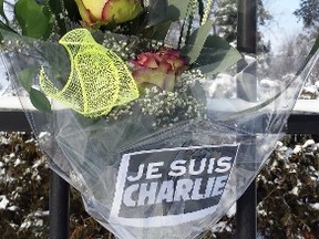 A bouquet of flowers attached to the fence at the French embassy in Ottawa Wednesday was one gesture of support Canadians showed to France following a terrorist attack in Paris. (Corey Larocque/QMI Agency)