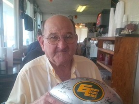 Harvey Allison, who owns Harvey's, an eatery in Chris Jones's hometown of South Pittsburgh, Tenn., holds an autographed Eskimos football. (Terry Jones, Edmonton Sun)