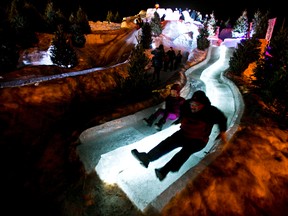Emily Pillott, 6, left, and her dad, Don (same last name) ride the slide during the Ice on Whyte festival at End of Steel Park in Edmonton, Alta., on Tuesday, Jan. 28, 2014. The festival runs until Feb. 2. Codie McLachlan/Edmonton Sun/QMI Agency
