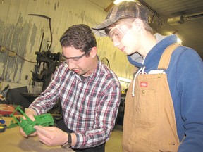 Rob Sterling (left) helps Ryan McKerrall restore an old toy tractor. The Chatham Township youth is also customizing the tractor to resemble his father’s John Deere 4320. Rob and Ryan were putting the finishing touches on the tractor as they get ready for the Chatham-Kent Toy Show and Sale, to be held this Sunday, Jan. 18.
BLAIR ANDREWS/ QMI AGENCY