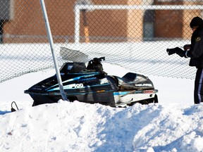 An OPP Central Region Technical Traffic Collisions investigator analyzes a wrecked snowmobile outside Crestwood Secondary School in Peterborough, Ont., Jan. 12, 2015. (CLIFFORD SKARSTEDT/QMI Agency)