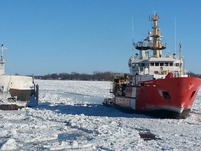 The Canadian Coast Guard Ship (CCGS) Samuel Risley escorts the freighter H. Lee White down the St. Clair River Tuesday. Both Canadian and U.S. coast guards continue to work on moving vessel traffic along the icy river. (Photo courtesy of KELLY MURRAY ABOARD THE CCGS GRIFFON)