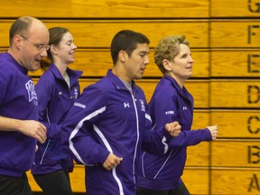 Ontario Premier Kathleen Wynne leads a group of Western University athletes, along with London Mayor Matt Brown, in a morning run at Thompson Arena on Tuesday. (CRAIG GLOVER, The London Free Press)