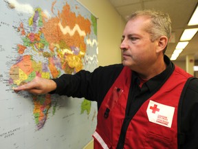 Sean Freeman points out on a map of Africa where he was working at the Red Cross offices in downtown Calgary, Alta. where he has returned from working at the Red Cross Ebola Treatment Centre in Kenema, Sierra Leone. on Monday January 5, 2015. Stuart Dryden/QMI Agency