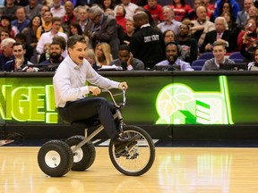 NASCAR driver Jeff Gordon rides a tricycle in a contest on the court during a time out in the Washington Wizards and San Antonio Spurs game at Verizon Center on January 13, 2015 in Washington, DC.  Rob Carr/Getty Images/AFP