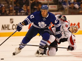 Leo Komarov of the Toronto Maple Leafs shoves away Troy Brouwe rof the Washington Capitals as both players go after the puck at the Air Canada Centre in Toronto on Jan. 8, 2015. (JACK BOLAND/Toronto Sun files)
