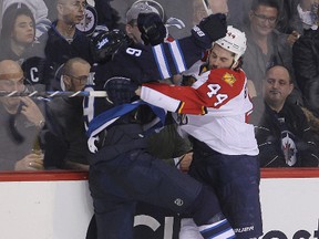 Winnipeg Jets left winger Evander Kane and Florida Panthers defenceman Erik Gudbranson tangle along the boards during NHL hockey at the MTS Centre on January 13, 2015. (Brian Donogh/Winnipeg Sun/QMI Agency)