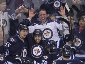 Fans react as Winnipeg Jets centre Mathieu Perreault (c) celebrates his fourth goal against the Florida Panthers with teammates Mark Scheifele, Toby Enstrom and Michael Frolik during NHL hockey in Winnipeg, Man. Tuesday, January 13, 2015.
Brian Donogh/Winnipeg Sun/QMI Agency