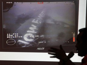 Head of the National Search and Rescue Agency Fransiskus Bambang Soelistyo is seen with an image believed to be of the fuselage of AirAsia Flight QZ8501, taken by an underwater ROV provided by the Singaporean Navy, during a news conference in Jakarta Jan. 14, 2015. REUTERS/Pius Erlangga