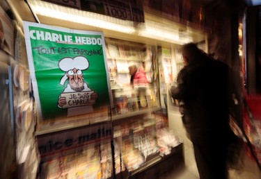 A poster showing the front page of the new issue of sold-out satirical French weekly Charlie Hebdo entitled "Tout est pardonne" ("All is forgiven"), with a caricature of Prophet Mohammad on the cover, is displayed at a kiosk in Nice, Jan. 14, 2015. REUTERS/Eric Gaillard