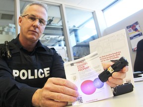 Const. Chris Moxley with Sarnia Police uses a black light to demonstrate a new Trace pen technology police are using to help return stolen items to their rightful owners. It's hoped the marking and tracking technology will also deter would-be thieves. (TYLER KULA/ THE OBSERVER/ QMI AGENCY)