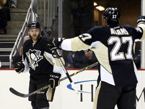 Pittsburgh Penguins right wing Bryan Rust (36) reacts with right wing Craig Adams (27) after Rust scored his first NHL goal against the Tampa Bay Lightning during the second period at the CONSOL Energy Center. The Penguins won 4-2. Mandatory Credit: Charles LeClaire-USA TODAY Sports