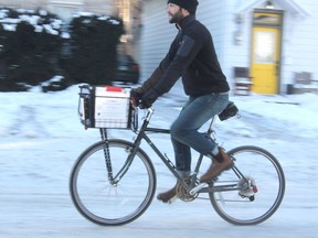 Eli Scheinman recently started up his own bike delivery business, delivering take-out food, groceries and other items to customers in the downtown area. (Michael Lea/The Whig-Standard)