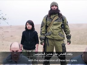 A young boy is shown apparently shooting two alleged Russian spies in a propaganda video released by ISIS.