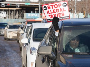 Taxi drivers surround Edmonton City Hall during an anti-Uber protest, in Edmonton Alta., on Wednesday Jan. 15, 2015. David Bloom/Edmonton Sun/QMI Agency