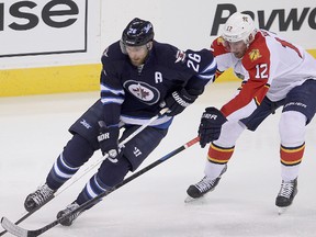 Winnipeg Jets right winger Blake Wheeler (l) and Florida Panthers right winger Jimmy Hayes fight for the puck during NHL hockey in Winnipeg, Man. Tuesday, January 13, 2015.Brian Donogh/Winnipeg Sun/QMI Agency
