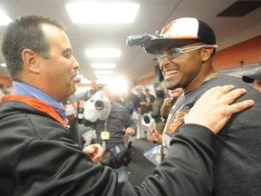 Baltimore general manager Dan Duquette (left) congratulates Nelson Cruz after the Orioles clinched the American League East title in a game against the Blue Jays this season. (Getty Images/AFP)