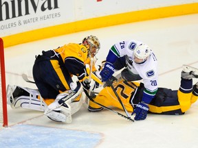 Nashville Predators goalie Pekka Rinne (35) is hit by Vancouver Canucks left winger Chris Higgins (20) on a play in front of the goal during the third period at Bridgestone Arena. (Christopher Hanewinckel-USA TODAY Sports)