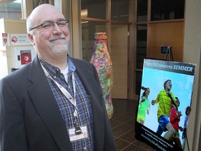 John Suart, the manager for community relations at Family and Children's Services of Frontenac, Lennox and Addington, in Kingston, stands in front of a giant Coke bottle decorated by children at a recent summer camp. A fundraising campaign to send more kids to camp is underway. (Michael Lea/The Whig-Standard)