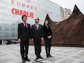 French President Francois Hollande, centre, and Culture minister Fleur Pellerin, right, and the President of the Institut du Monde Arabe (Arab institute), Jack Lang, left, walk past the Arab Institute building bearing the message 'We are Charlie', in Paris on Jan. 15. Seventeen people were killed last week in attacks, which included the offices of the satirical French weekly Charlie Hebdo. (Ian Langsdon/Reuters)