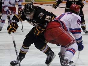 Sarnia Sting forward Pavel Zacha slips around the check from Kitchener Rangers blueliner Dmitrii Sergeev during the Ontario Hockey League game at RBC Centre in Sarnia Thursday night. Zacha scored the game-tying goal in the final minute of regulation but the Rangers won 3-2 in overtime. (TERRY BRIDGE, The Observer)