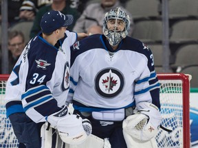 Jan 15, 2015; Dallas, TX, USA; Winnipeg Jets goalie Ondrej Pavelec (31) and goalie Michael Hutchinson (34) celebrate the win over the Dallas Stars at the American Airlines Center. The Jets defeated the Stars 2-1. Mandatory Credit: Jerome Miron-USA TODAY Sports