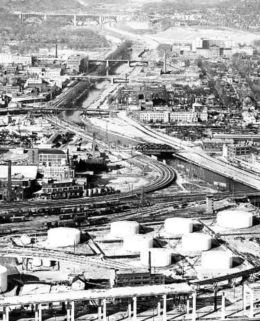 Mike Filey's The Way We Were for Jan. 18, 2015.

This unusual photograph was taken in February 1953 as work progressed on the new Don Valley Pkwy. taking shape just to the east of the Don River. The view looks north up the river from just north of the cross waterfront rail corridor. The industrial area in the foreground is presently being developed by Waterfront Toronto and will be known as the West Don Lands. The 32-hectare (80-acre) site is being transformed into a sustainable, mixed-use, pedestrian-friendly, riverside community. This revitalized community will feature 6,000 new residential units, ample employment and commercial space, at least one elementary school, and two child-care centres, all surrounded by nearly 9.3 hectares (23 acres) of parks and public spaces. During the Pan/Parapan Am Games this summer it will be the site of the Athletes� Village. In this view we see the various bridges that cross the Don River. From the bottom to the top of the photo are the Eastern Ave. bridge (closed to all traffic when the Don Valley Pkwy. was built), the Queen St. high level bridge (built in 1909-11 to eliminate a dangerous at-grade railway crossing), the Dundas St. bridge, the Gerrard St. bridge, the pedestrian foot bridge at Riverdale Park and in the distance the Don Valley section of the majestic Prince Edward Viaduct, the official title that replaced the original Bloor St. Viaduct name following the Prince of Wales visit to the city in 1919. The entire structure from Sherbourne St. to Broadview Ave. was officially opened on Oct. 18, 1918 with the long anticipated streetcar route across the bridge, a welcomed �shortcut� that reduced travel time by as much as 15 minutes, began on Dec. 15. (Toronto Telegram photo)
