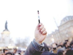 A man raises a pen in the Place de la Republique in Paris on Jan. 7 during a rally in support of the victims of that day?s terrorist attack on French satirical newspaper Charlie Hebdo. (Martin Bureau/AFP Photo)