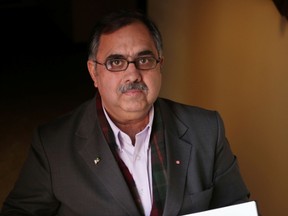 Syed Atta-ur-Rehman, president of the Pakistan Canada Association of Kingston, holds the book of condolences he delivered to the families of those killed in a Taliban attack on a school last month. (Elliot Ferguson/Whig-Standard file photo)