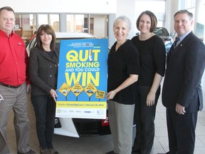 Gathered at the Kingston Toyota dealership to promote the Canadian Cancer Society's Driven To Quit Challenge, a contest where people try to quit smoking to win a car, are, from left, Bruce Stuart from the dealership, contest participant Carole Huntbach, Barbara Hollander from the Canadian Cancer Society, Nicole Szumlanski from KFL&A Public Health, and Doug Kane, manager of the local cancer society. (Michael Lea/The Whig-Standard)